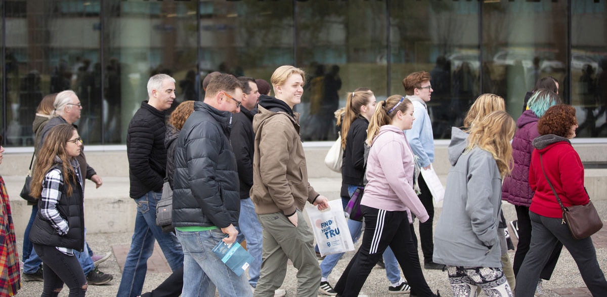 Large group of students walking across campus